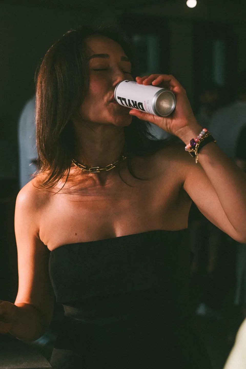 Woman drinking a DRYLL can